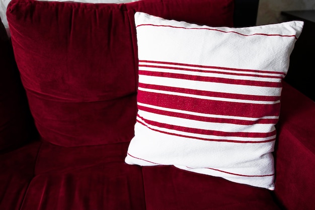 Interno soggiorno con divano e cuscino decorativo in primo piano viva colore magenta dell'anno 2023 camera