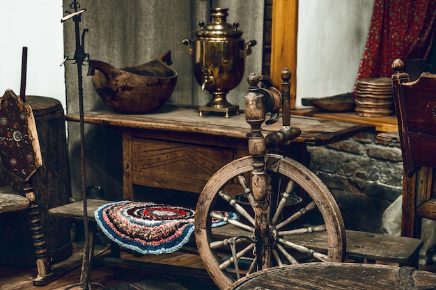 Living room with antique furniture and outdated utensils Rural life of Russian peasants Spinning wheel and samovar Premises of old hut Inside view