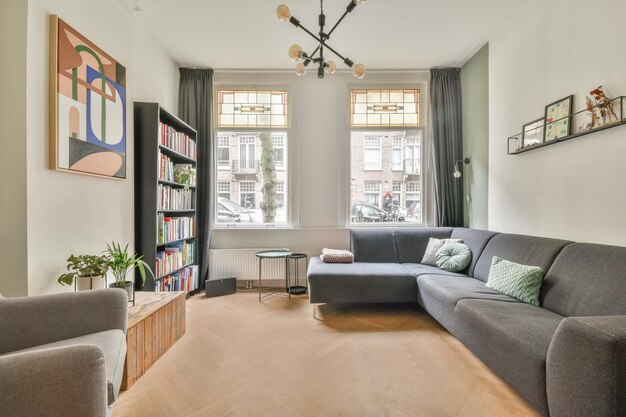 Photo a living room with a gray couch and a window