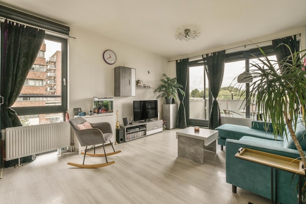 A living room with green furniture and a large window