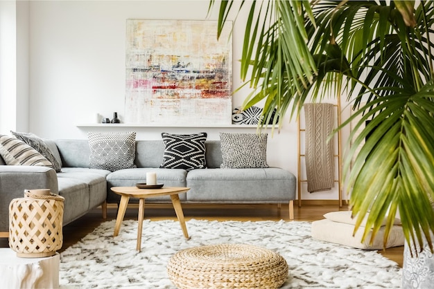 A living room with a large palm tree in the corner.