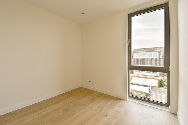 a living room with a large window and wooden floors