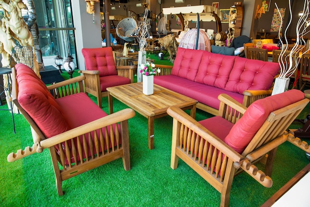 A living room with a red couch and a wooden table with a wooden table and chairs.