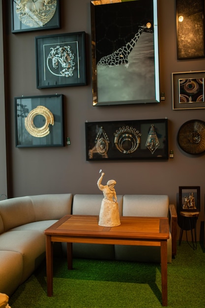 A living room with a sofa, a table, and paintings on the wall.