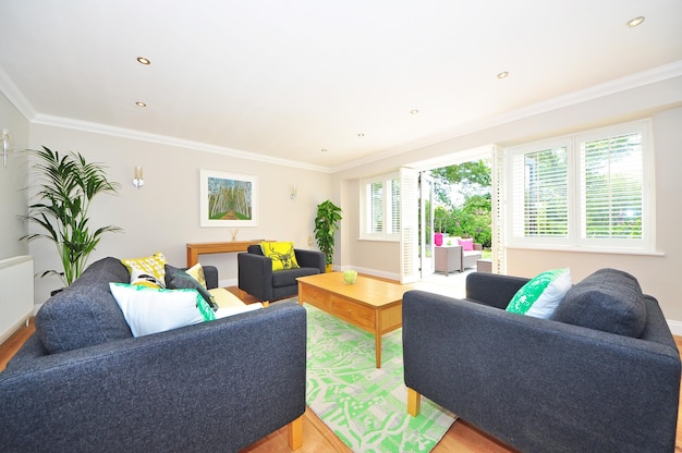 A living room with a sofa and a table with a sign that says'home'on it