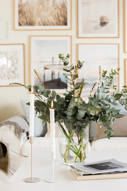 Foto un soggiorno con un divano bianco, un tavolo bianco e un vaso di eucalipto.