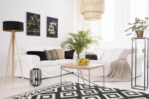 A living room with a white sofa and a black and gold rug with a black and white rug with a gold and black rug.