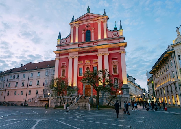 슬로베니아 류블랴나 - 2018년 4월 27일: 프란체스코 수태고지 교회와 슬로베니아 류블랴나의 프레세렌 광장에 있는 사람들. 늦은 저녁