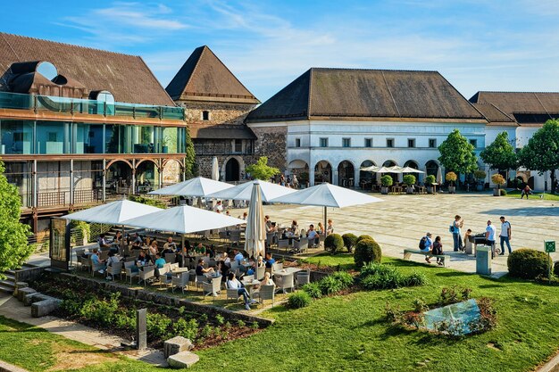 Ljubljana, Slovenië - 27 April 2018: Sidewalk café met mensen in de binnenplaats in het oude kasteel op Castle Hill in het historische centrum van Ljubljana, Slovenië