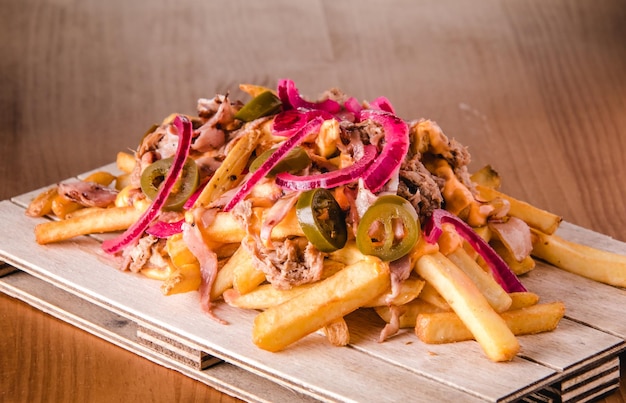 Loaded french fries with pulled pork, jalapenos, cheddar sauce and onion