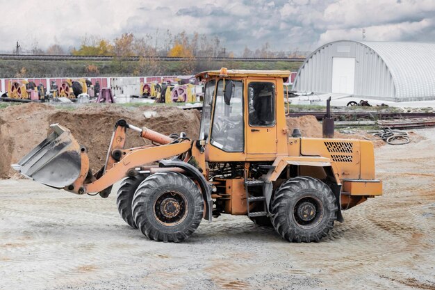 The loader is transporting sand or gravel in the front bucket Heavy construction equipment at a construction site Transportation of bulk materials in a concrete plant