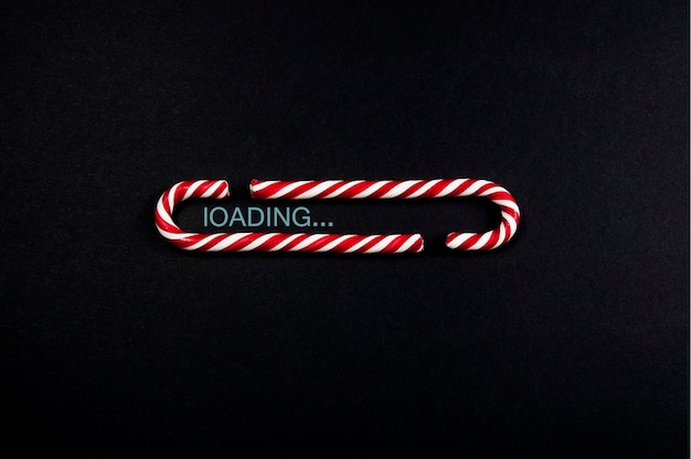 Photo loading bar made of christmas candies on a black matte background