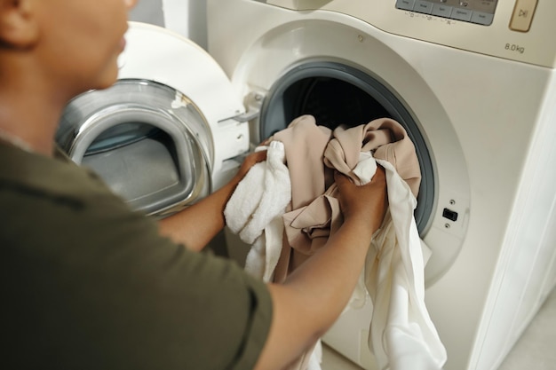 Loading Laundry in Washing Machine at Home