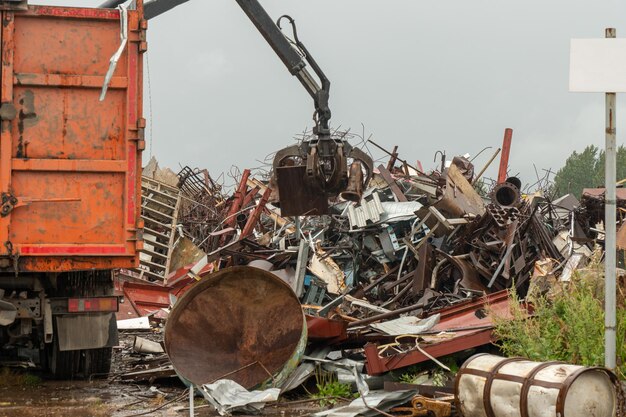 Loading of scrap metal by hydraulic crane, for recycling.