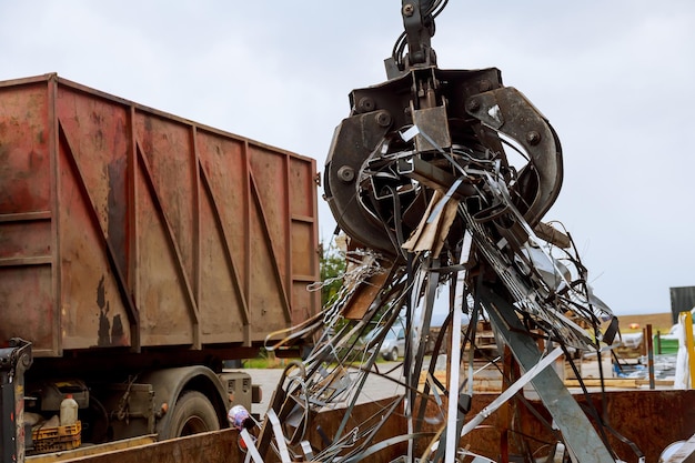 Caricamento di rottami metallici in un camion gru grabber caricamento di rottami metallici arrugginiti nel dock