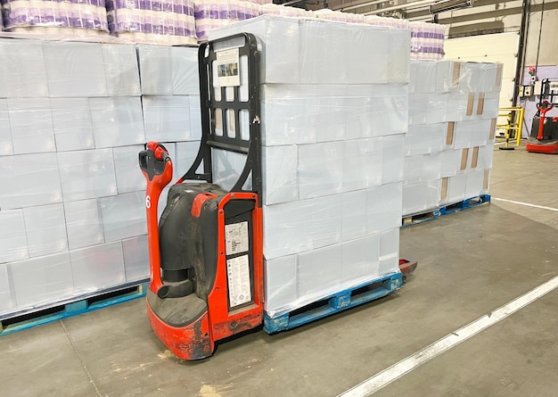 Foto carico e scarico del carico su pallet utilizzando un carrello elettrico semovente