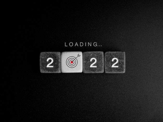 Photo loading year concept. word and year numbers on black and white cube blocks with target icon sign in the progress bar on dark. business update, upgrade ideas, creative thinking concepts.