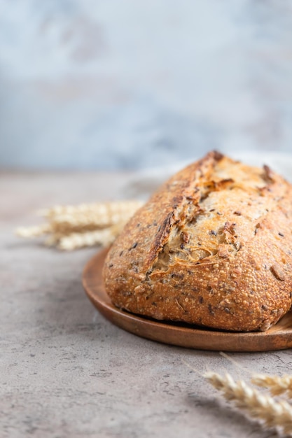 Photo loaf of artisan sourdough bread with wheat ears and linen napkin tartine with multigrain seeds