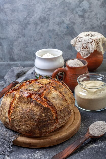 Loaf of artisanal bread and different types of flour