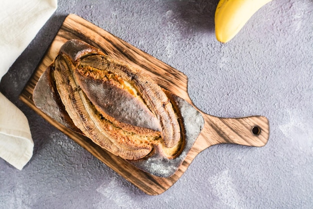 A loaf of baked banana bread on a cutting board on the table Social media trendy Top view