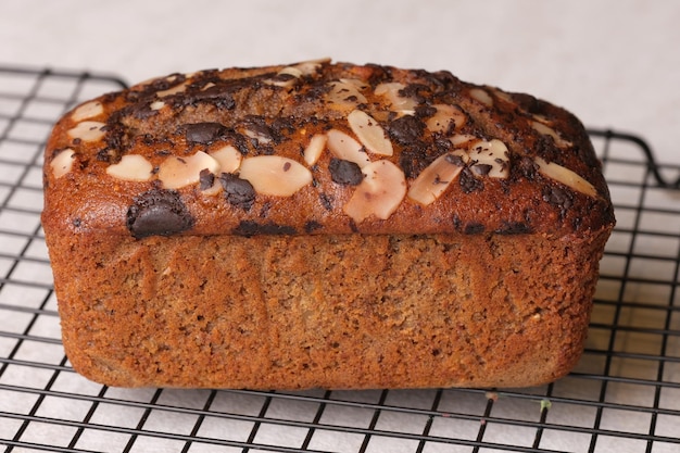 Photo a loaf of banana bread with chocolate chips on a wire rack.