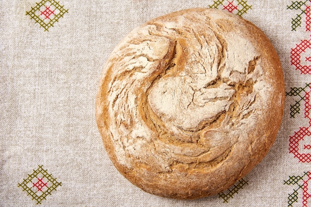 A loaf of bread on top of a linen tablecloth