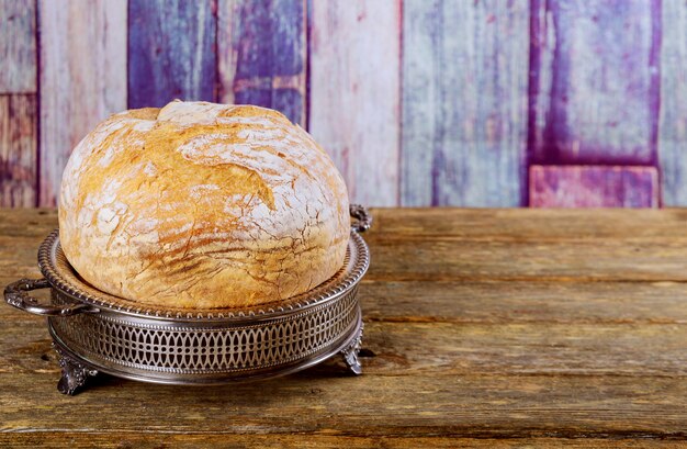 Loaf of bread on wooden background, food closeup