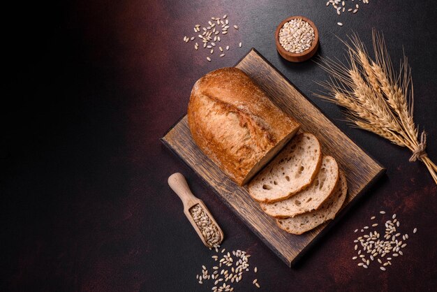 A loaf of brown bread with grains of cereals on a wooden cutting board