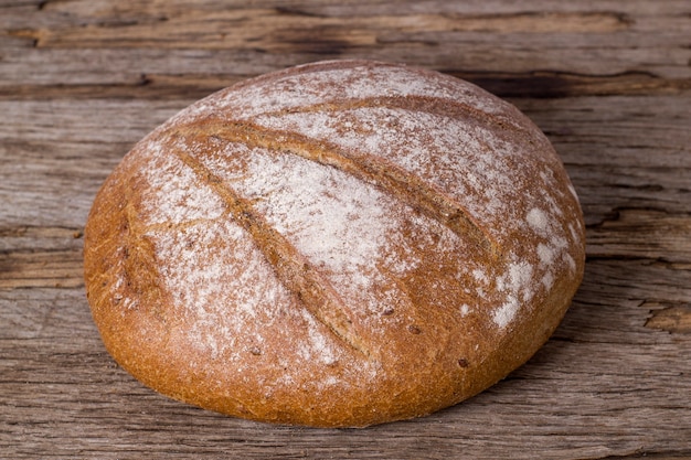 Loaf of buckwheat bread on wooden background.