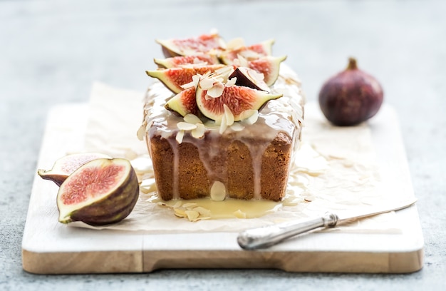 Loaf cake with figs, almond and white chocolate on wooden serving board