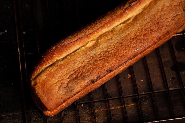 A loaf of French bread in an oblong shape on a dark background