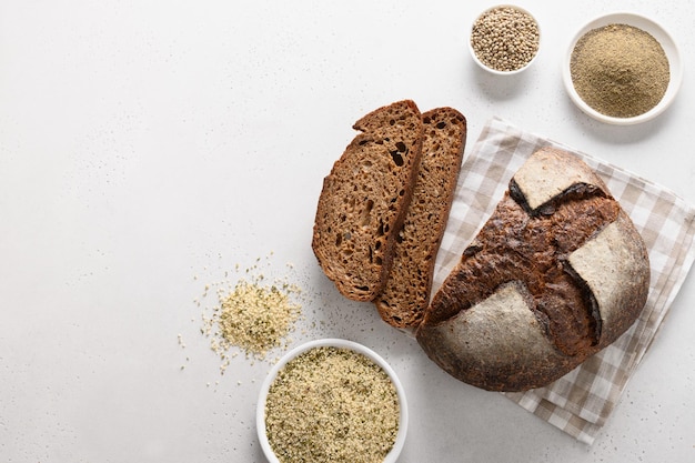 Loaf of freshly baked hemp bread and hempseeds on white background