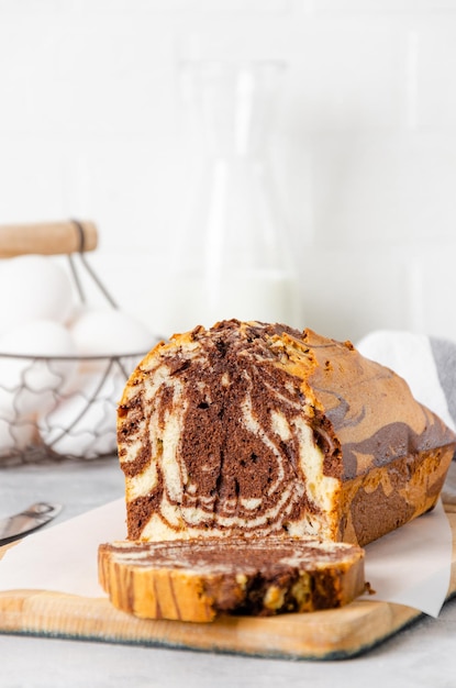 Loaf of marble pound cake on a board on a gray concrete background. Copy space.