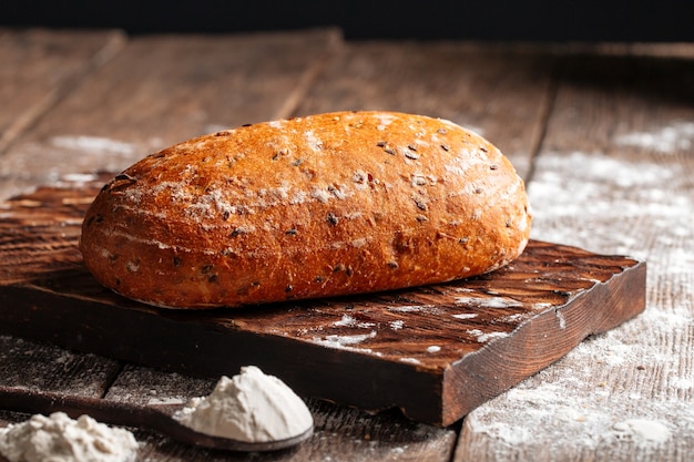 Буханка белого пшеничного хлеба на деревянной доске