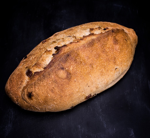 Loaf of white wheat flour on a black surface