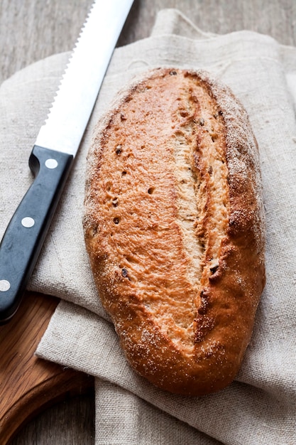 Loaf of whole wheat bread wooden board on kitchen table