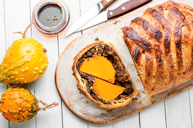 Loaf with baked pumpkin and mushrooms.Wellington pumpkin, autumn traditional food.