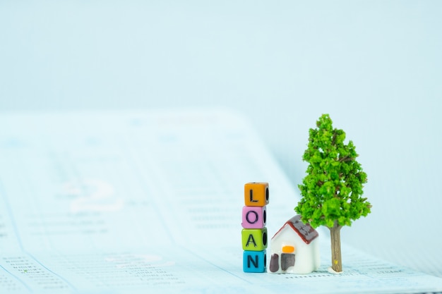Кредитный текст и маленькая модель дома и маленькое дерево с блокнотом