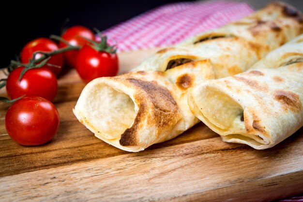 Foto panini di pane con pomodori cherry su un tavolo da taglio su uno sfondo nero