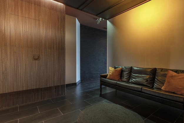 Lobby of a commercial premises with a white wall and a black wall in white and a long sofa with a modern design