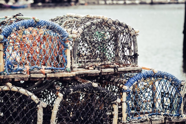 Photo lobster and crab pots traps stacked on harbour.