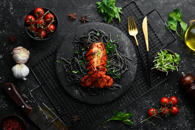 Lobster tail baked in garlic sauce and black pasta with cuttlefish ink Luxury restaurant food Seafood Rustic style Flat Lay