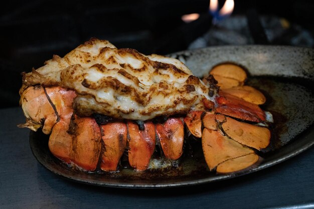 Photo lobster tail cooked to perfection in a cast iron skillet with a goldenbrown broil