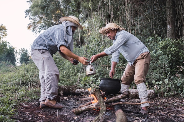 Photo local farmers drinking mate tea at their break time in a rustic teapot.