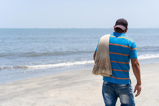 海に行く準備をしている漁網を持つ地元の漁師