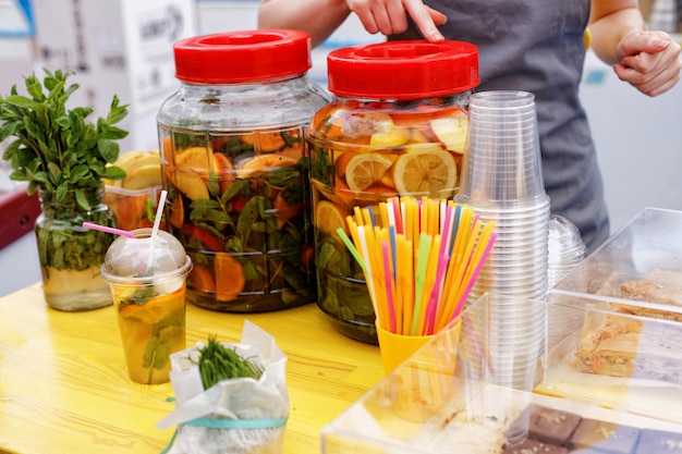 Local food festival. Large bottles of fresh lemonade and fruit