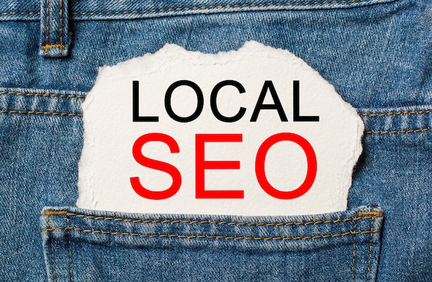 LOCAL SEO on torn paper background on jeans business and finance concept