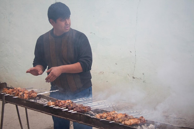 Местный сельский житель готовит мясо по-узбекски