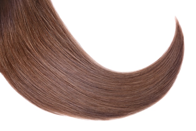 Lock of natural smooth blond hair on a white surface