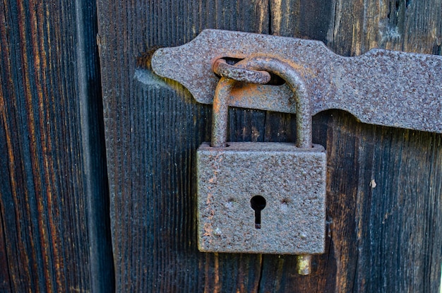 lock on an old wooden door with rusty inserts